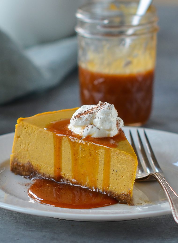 Slice of pumpkin cheesecake dripping with caramel sauce.
