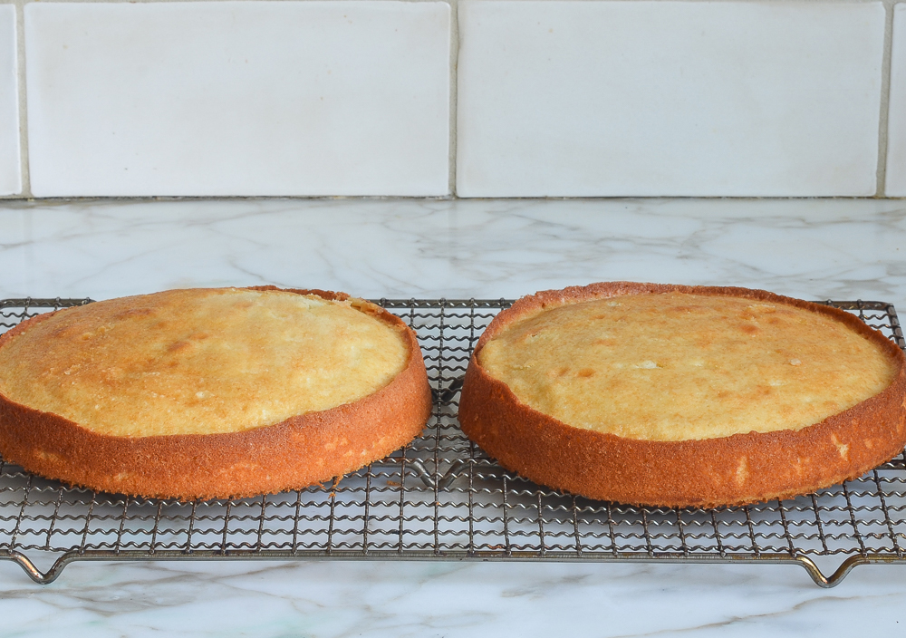 Two round cakes on a wire rack.