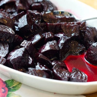 Spoon in a dish of roasted beets.