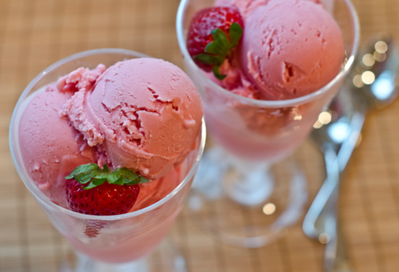 Two stemmed glasses of strawberry frozen yogurt.