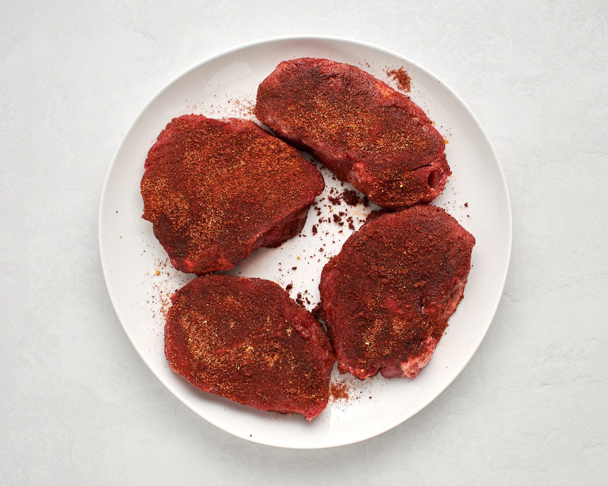 steaks seasoned with spice rub.