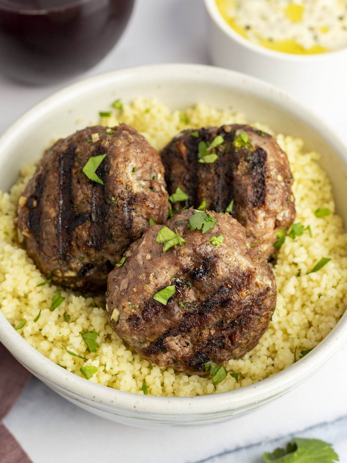grilled moroccan meatballs in bowls with couscous.