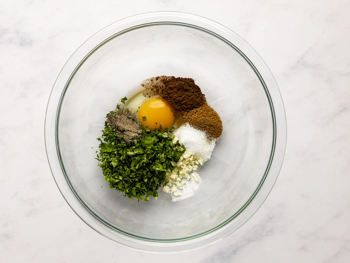Egg, garlic, cilantro, cumin, allspice, salt and pepper in a medium bowl.