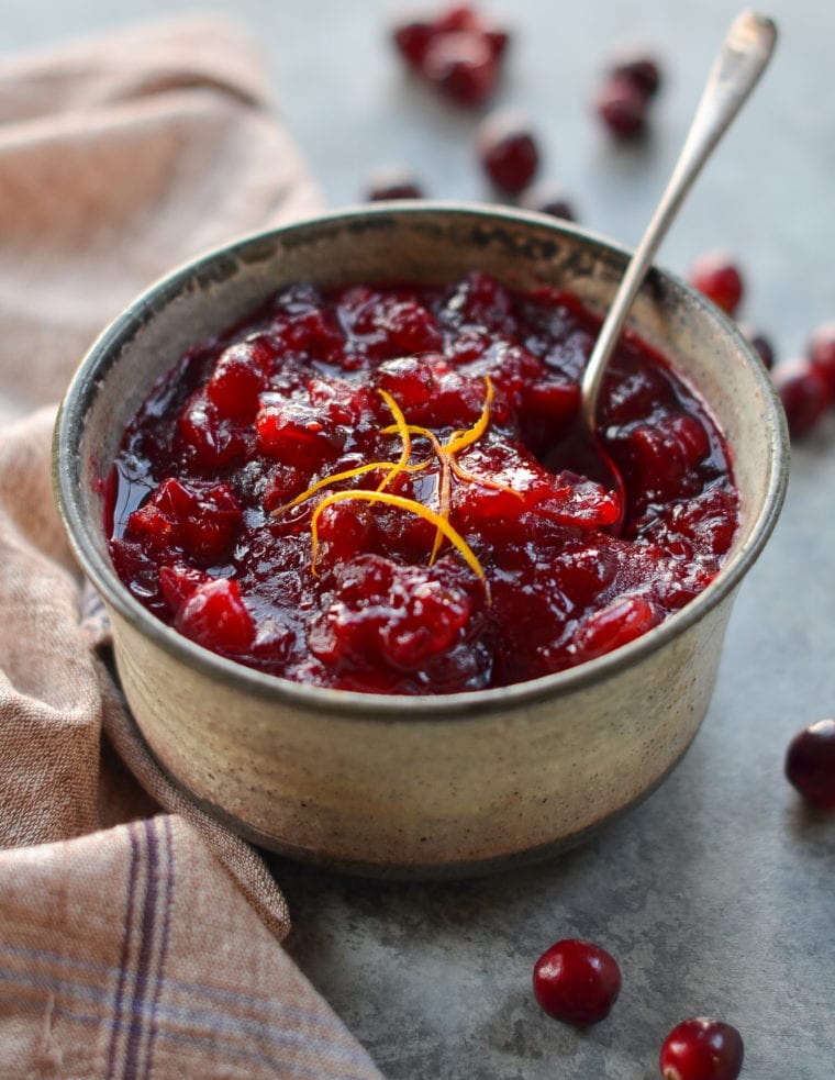 Spoon in a small bowl of cranberry sauce.