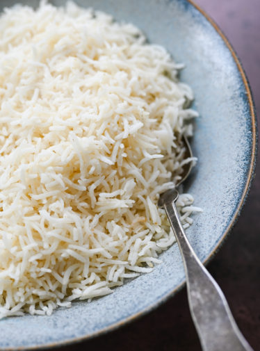 Spoon in a bowl of basmati rice.