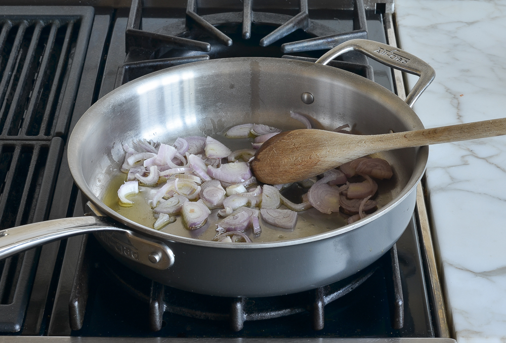 adding shallots to oil in skillet
