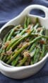 Spoon in a dish of French green beans with shallots.