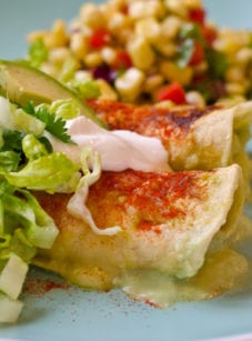 Enchiladas on a plate with corn.