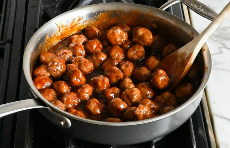 baked cocktail meatballs simmering in the sauce