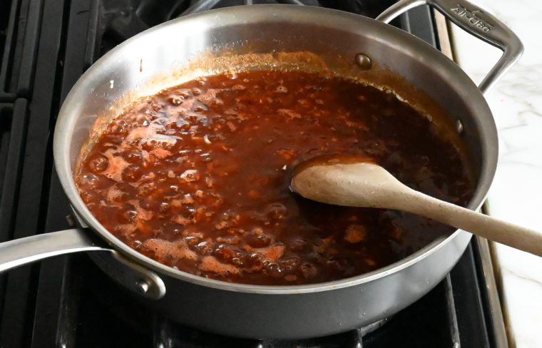 Pan of simmering sauce.
