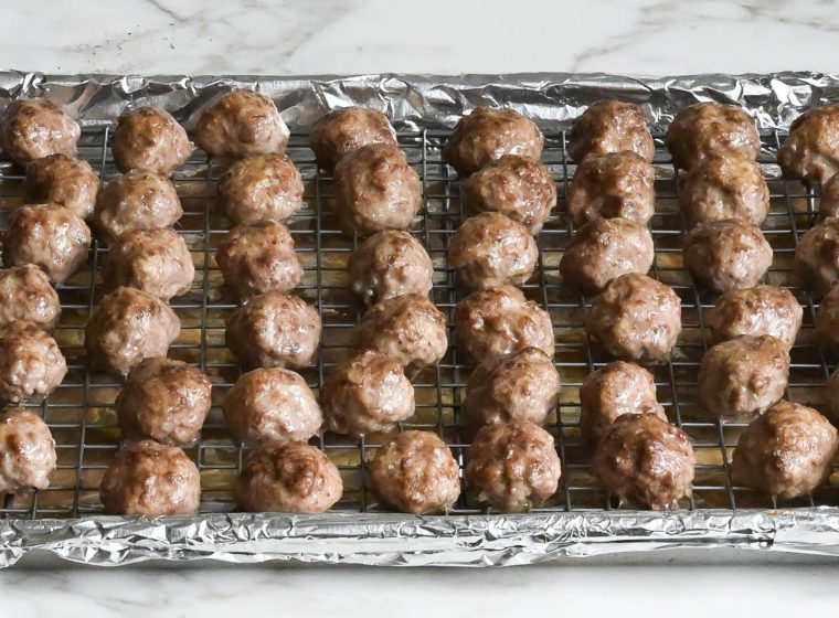Cooked meatballs on a wire rack.