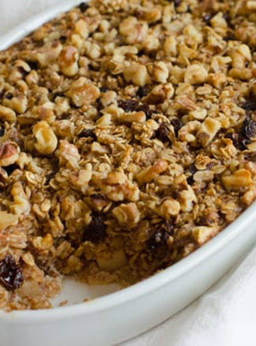 Baking dish of Amish-style baked oatmeal with apples, raisins, and walnuts.