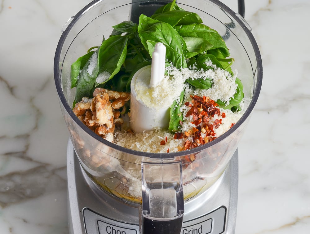 pesto ingredients in bowl of food processor