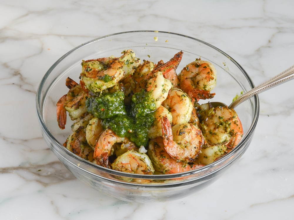 adding pesto to grilled shrimp