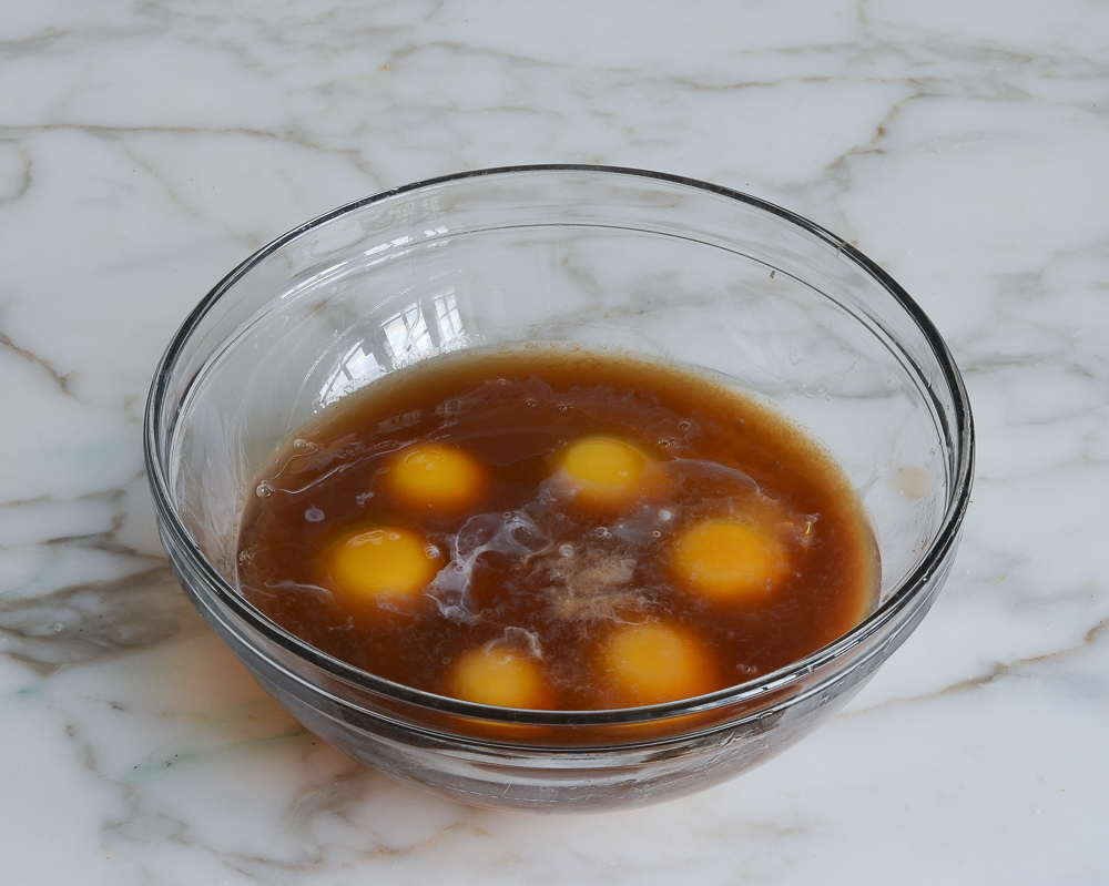 Eggs, egg yolks, rum, vanilla extract and almond extract in a mixing bowl to make rum cake