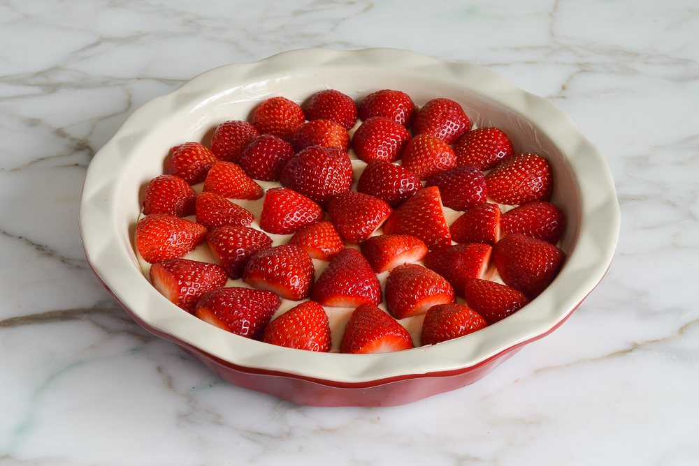 topping the batter with strawberries