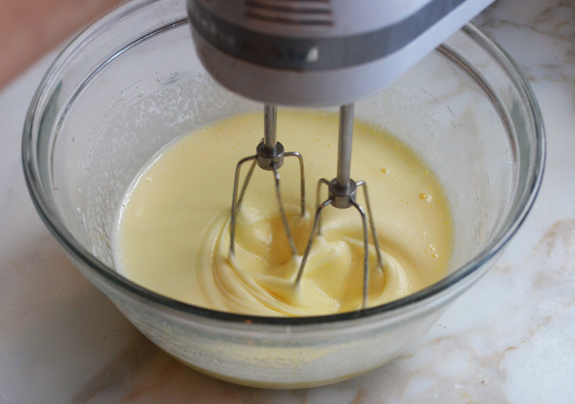 Mixer in a bowl with an egg and sugar mixture.