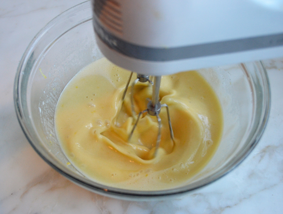 Electric mixer beating a wet mixture in a bowl.