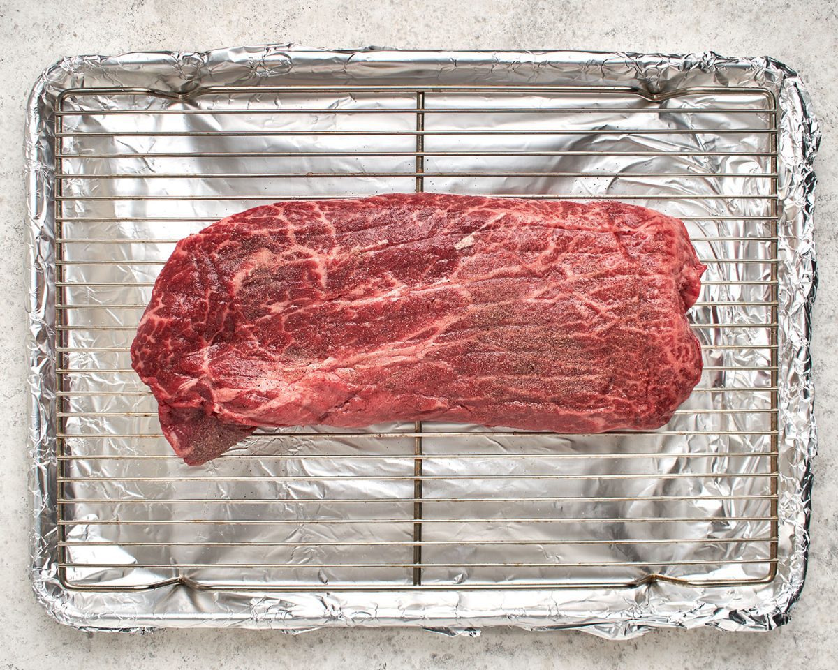 seasoned steak on broiler pan.