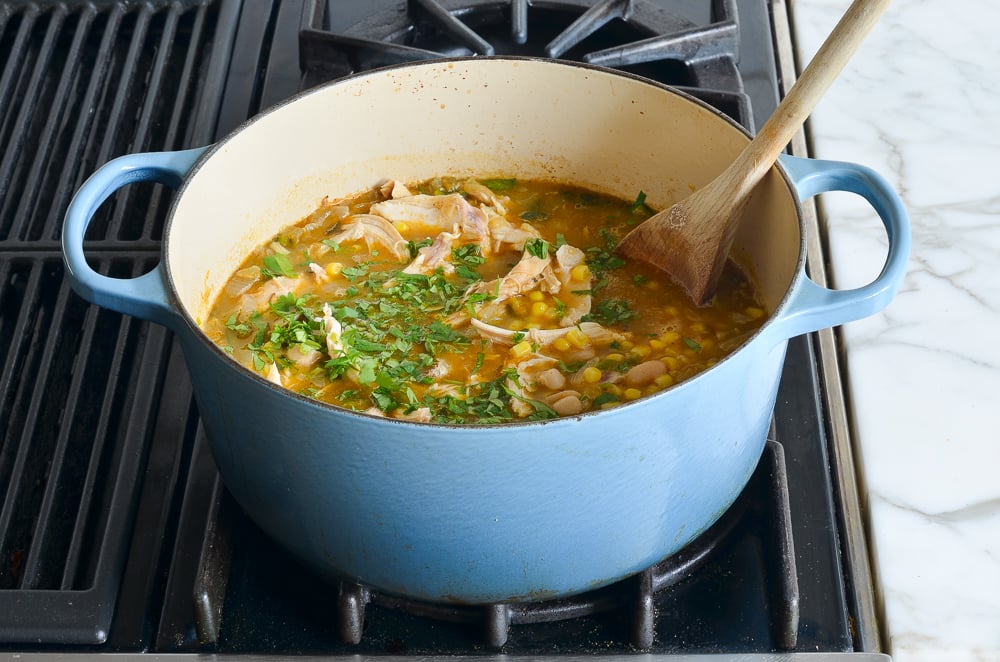 finishing the chili with cilantro