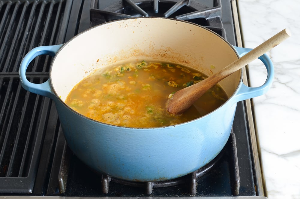 adding the broth and puréed beans