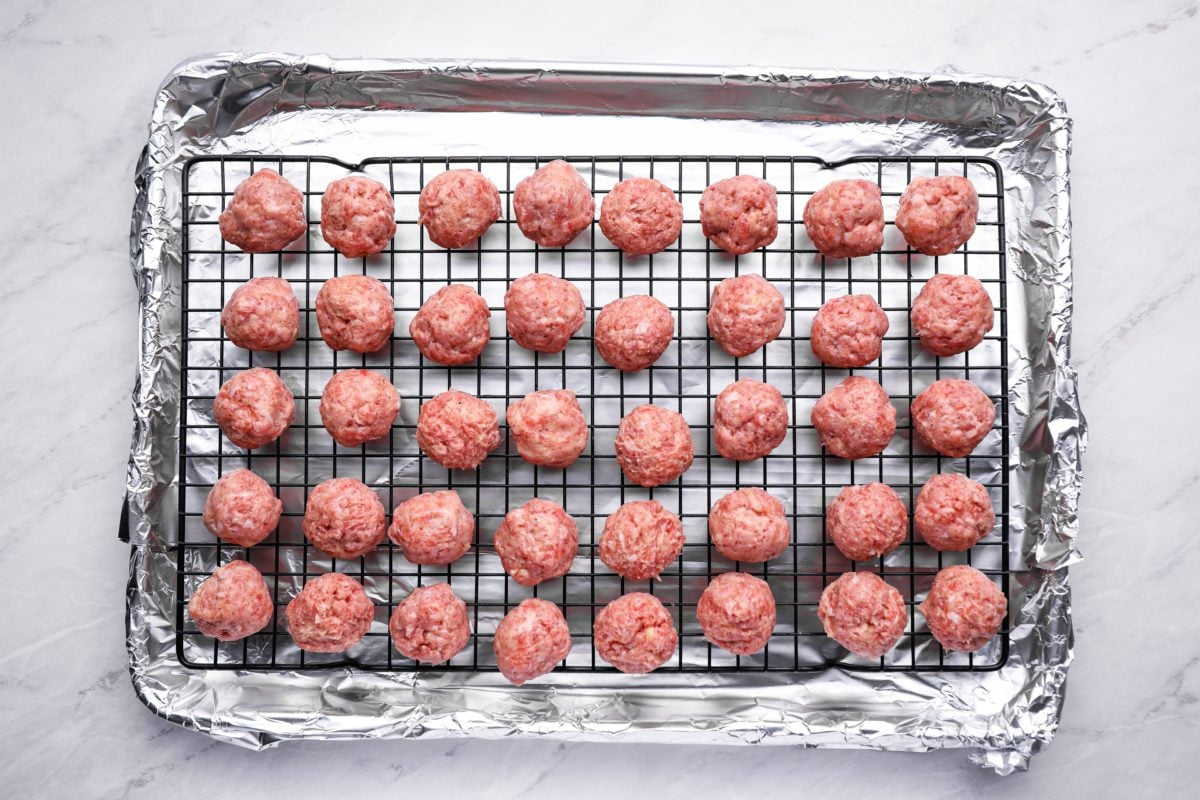 Swedish meatball mixture rolled into balls on baking sheet