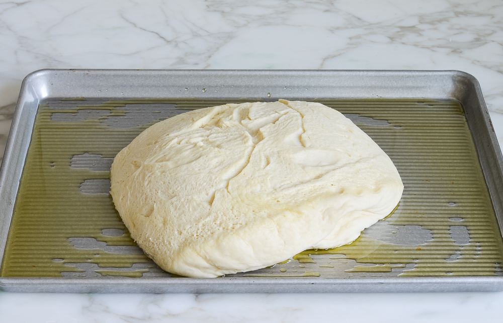 placing dough on oiled baking sheet