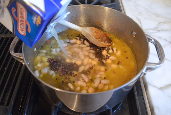 adding beans and broth to pasta e fagioli