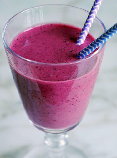 Bright smoothie with two straws.