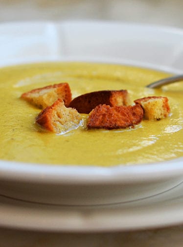 Bowl of broccoli soup topped with croutons.