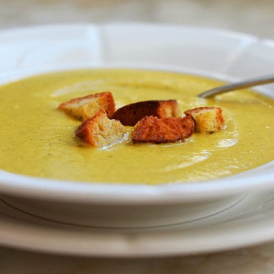 Bowl of broccoli soup topped with croutons.