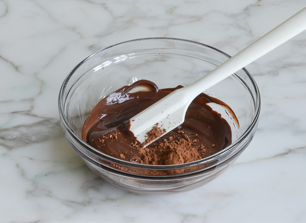 adding cocoa powder to melted chocolate