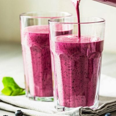 pouring berry smoothie into glasses