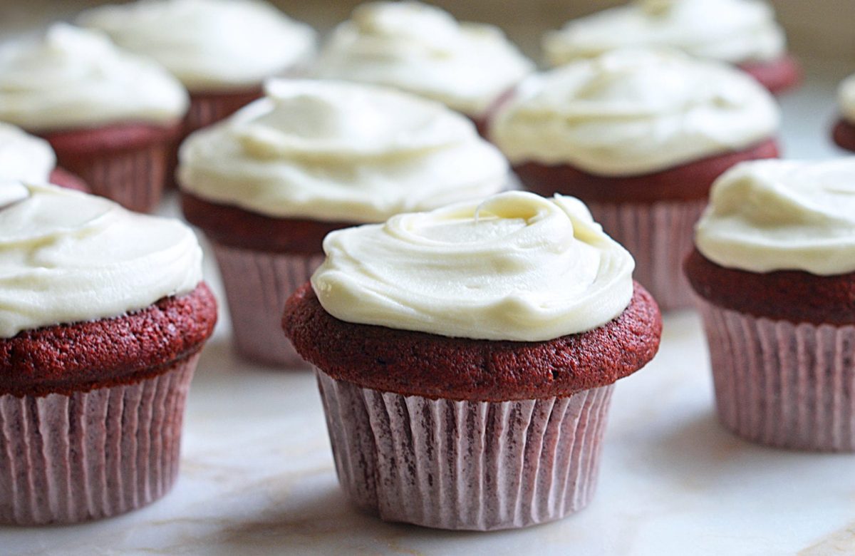 red velvet cupcakes with cream cheese frosting on marble.