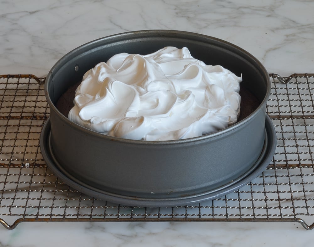 swirling meringue over baked cake