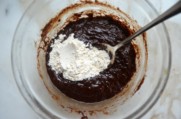 Flour in a bowl of melted chocolate with egg.