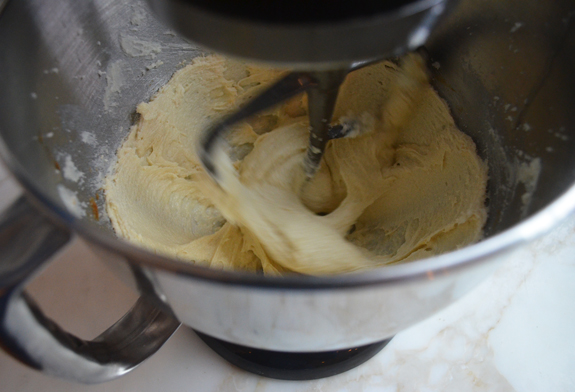 Egg and vanilla added to a stand mixer with a butter and sugar mixture.