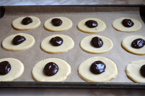 Circles of dough topped with dollops of chocolate.