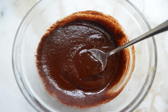 Spoon stirring sugar into a bowl of chocolate.