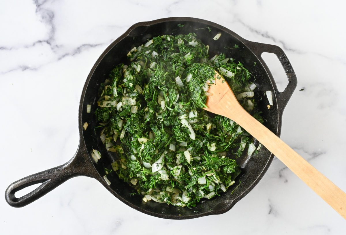 cooking the spinach and garlic with the onions