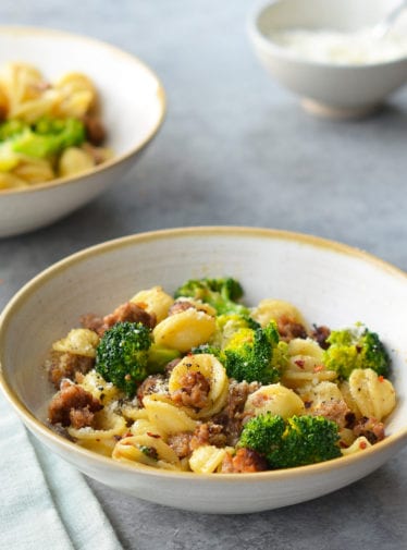 Bowls of orecchiette with sausage and broccoli.
