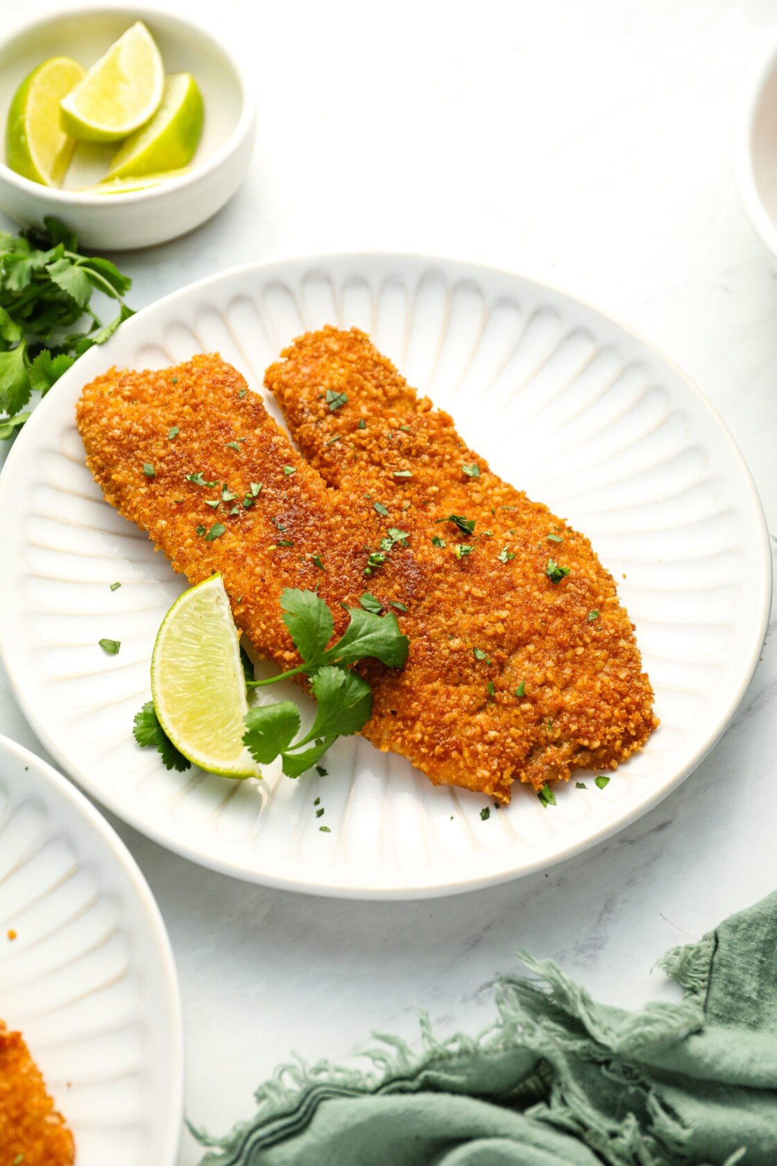 tortilla-crusted tilapia on plate with lime wedge