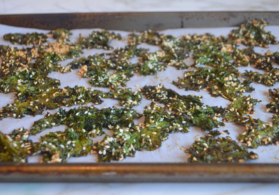 Maple sesame kale chips on a lined baking sheet.
