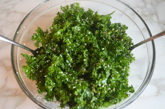 Bowl of kale tossed with maple syrup and sesame seeds.