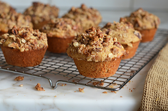 Oat muffins with pecan streusel topping cooling on a wire rack.