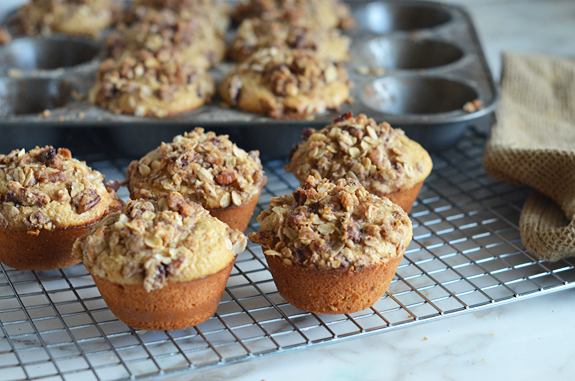 Oat muffins with pecan streusel topping cooling on a wire rack.