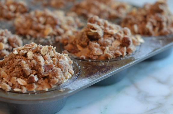 Oat muffins with pecan streusel topping in a muffin tin.
