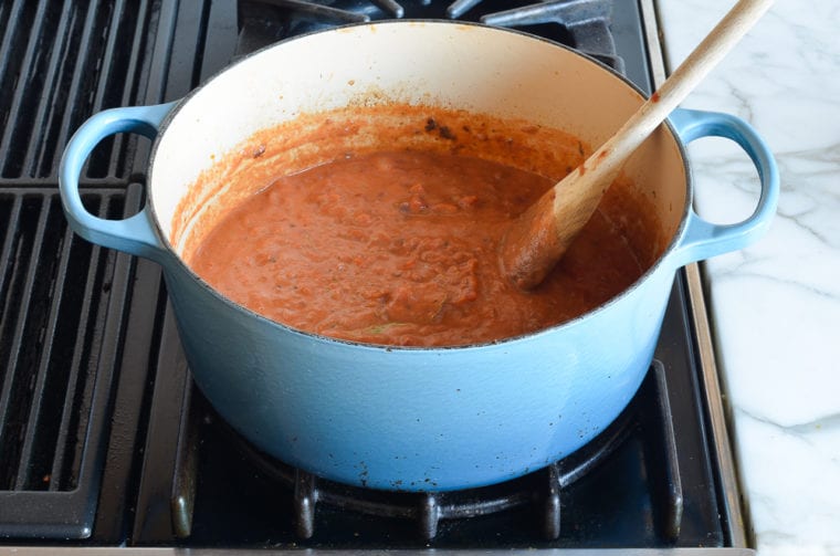 stirring lasagna sauce