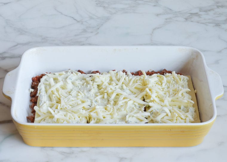 adding mozzarella cheese to lasagna layers