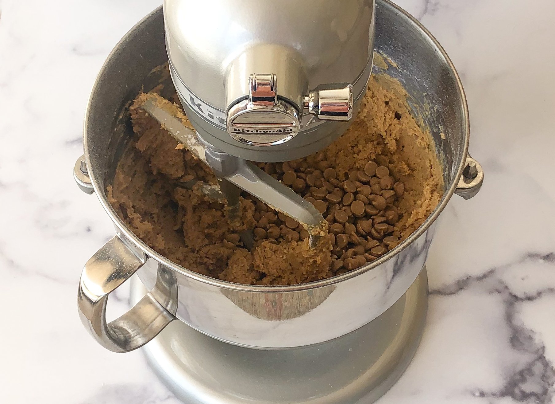 Adding the peanut butter chips and peanuts to the stand mixer.